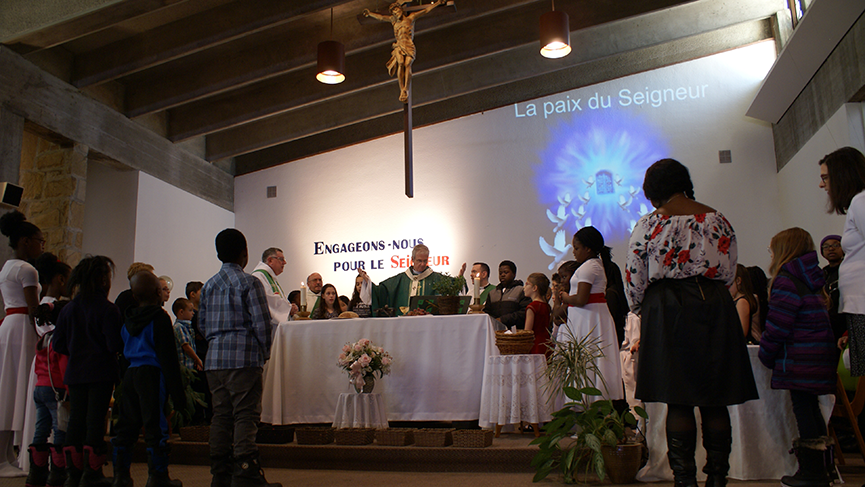 Lors de la prière du Notre Père, à l'église Saint-Marcel, Mgr Christian Lépine était entouré de nombreux enfants.