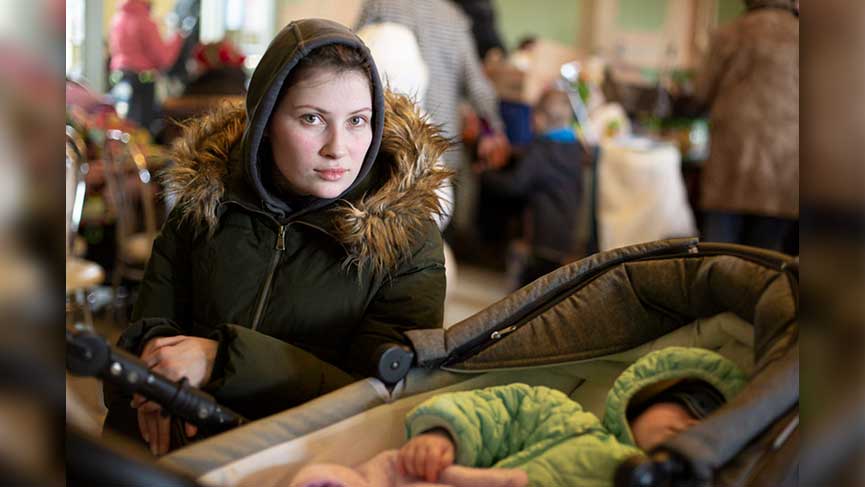 Une réfugiée ukrainienne et son bébé reçoivent de l’aide humanitaire de Caritas Pologne à la gare de Przemysl. 