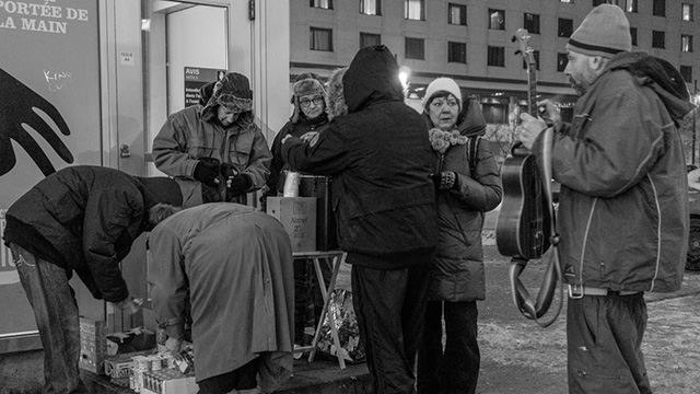 Father Paradis giving food to the homeless during winter