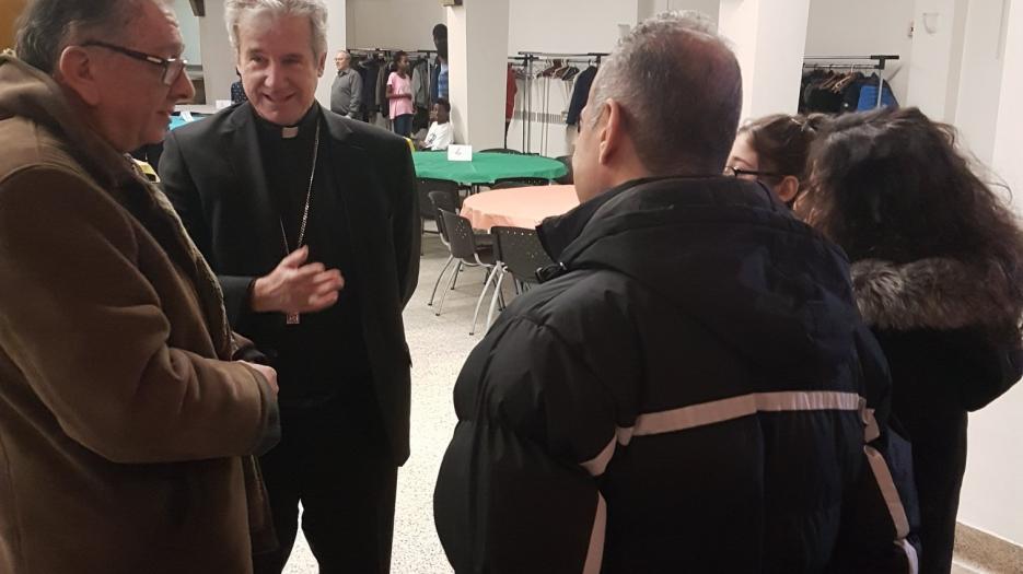 Msgr. Lépine discussing with a Syrian family.