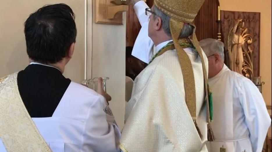 Mgr Lépine bénit les croix de consécration de l'église. (Photo : Dominic Richer, prêtre)