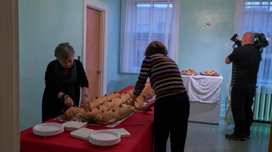 Les bénévoles préparent le buffet qui sera servi aux invités au lancement. (Photo : Richard Maltais)