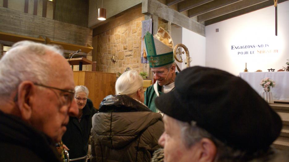 As usual, Most Rev. Lépine meets all the parishioners after each Mass and takes the time to pray with them and for them. (Photo : Brigitte Bédard)