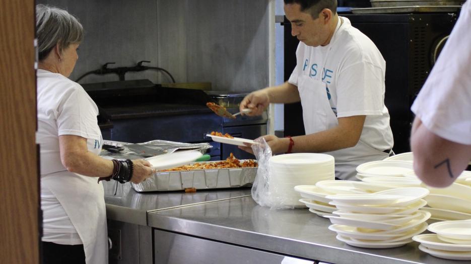 Bénévoles et bénéficiaires s’activent en cuisine pour servir le repas