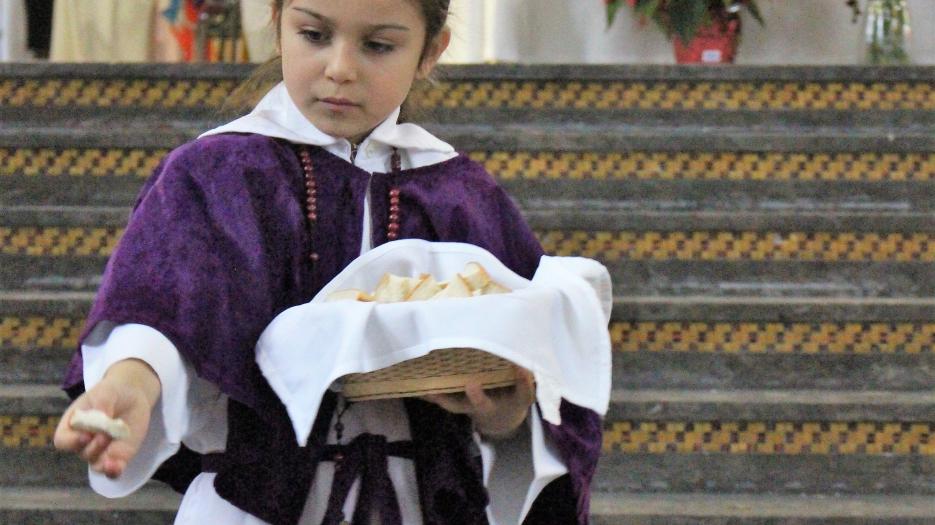 Distribution de la petite communion aux enfants. (Photo : Isabelle de Chateauvieux)